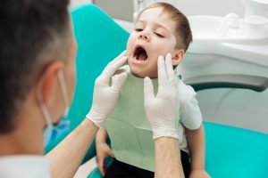 Dentist checking for tooth decay to apply fissure sealants in Chelsea MA